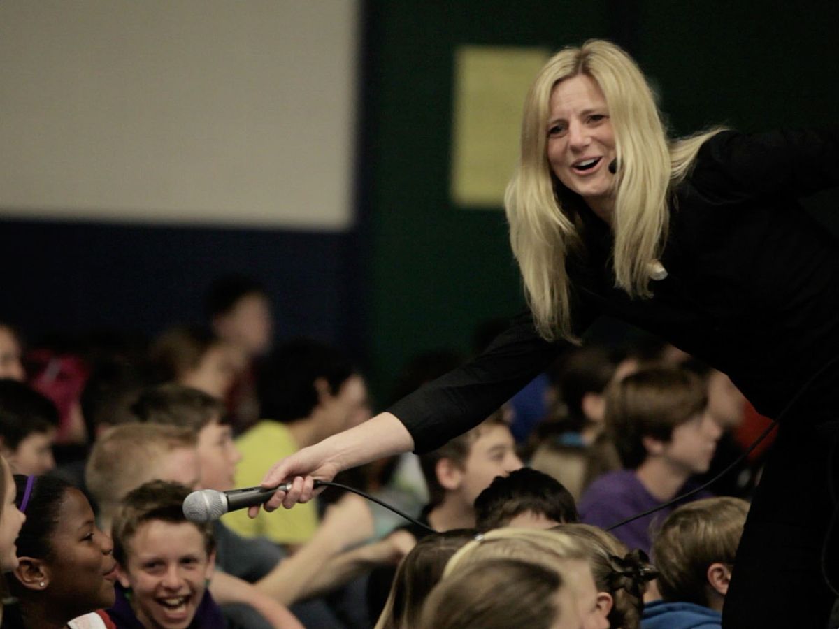 Sonya White sharing the microphone with laughing school children
